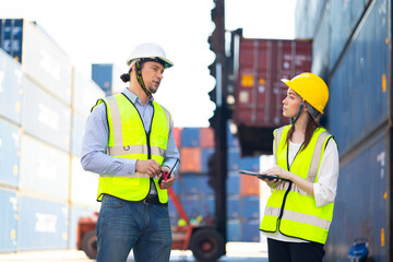 Man manager and woman Supervisor dock cargo checking  and control loading Containers box at container yard port of import and export goods. Unity and teamwork concept