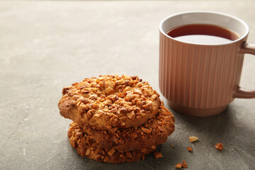 Peanut cookies with tea on grey background. Bakery products.