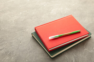 Green and red notebook on grey background. Top view