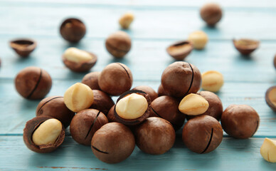 Peeled macadamia nuts. Horizontal composition on blue background.