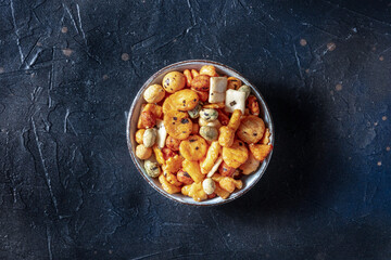 Japanese rice crackers in a bowl on a black slate background, overhead shot