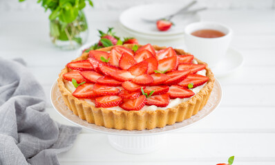 Strawberry tart with custard cream on a plate on a white wooden background. Copy space. - obrazy, fototapety, plakaty