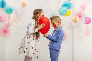 Cute couple of kids with red heart balloon.