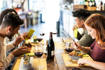 Multiracial friends eating poke bowl at fusion restaurant - Food and beverage lifestyle concept with happy people having fun together at fusion bar - Warm neon filter with focus on the girl at right