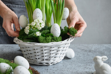 DIY Easter table centerpiece with festive eggs, moss and bunny. Spring composition. Floral workshop.