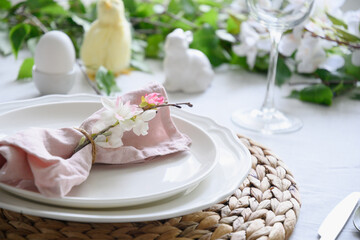 Fototapeta na wymiar Easter table setting with yellow chick,decorations, fresh flowers and eggs. Elegance dinner. Close up.
