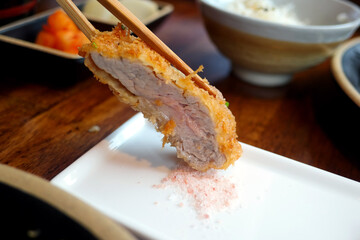 Dip a piece of pork cutlet in salt.