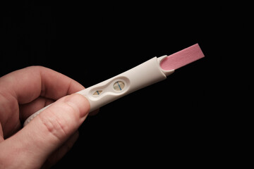 Two line pregnancy test and hand.