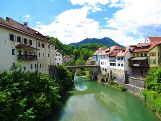 Fototapeta na wymiar Kamniti most bridge over Selska Sora river in Skofja Loka, Slovenia and Lubnik hill behind