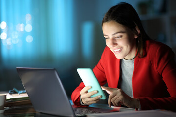 Businesswoman checking phone smiling at home