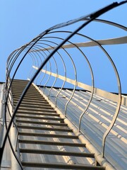 Fototapeta premium Stairs climbed onto the roof of a large factory with a clear sky atmosphere. Fire exit building.