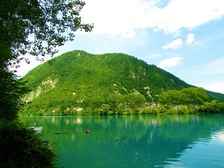 Obraz premium Lake at Most na Soci and a forest covered hill behind Littoral region of Slovenia in summer