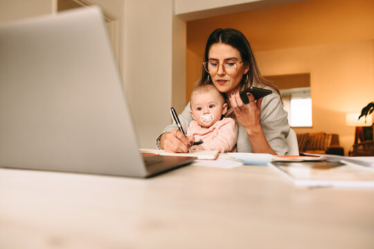 Working mom making notes during a phone call