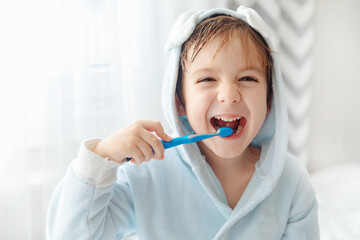 Morning routine, smiling happy child brushing teeth with toothbrush. Dental hygiene of little boy,...
