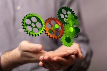 Mechanism, green metallic gears and cogs at work on brown background. Industrial machinery. 3D