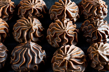 Dark marshmallows in chocolate on a dark background, homemade dessert, side view