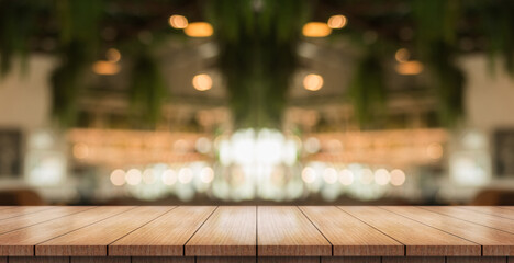 Empty wooden table top with lights bokeh on blur restaurant background.