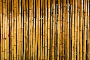 Old brown tone bamboo simple wall or Bamboo fence texture background for interior or exterior design vintage tone. Brown bamboo stick pattern backdrop. Local area urban house protection from thief.