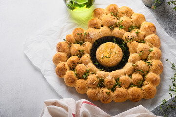 Roasted camembert cheese and homemade bread heart shaped and thyme on rustic background. French cheese. Concept of romantic love for Valentines Day. Top view, copy space.