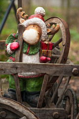 Christmas elk figure with presents.
Decorative figure elk on old wooden cart. Natural blurred background.
