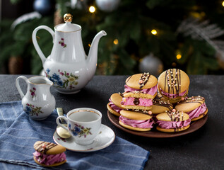 Homemade black currant marshmallows with cookies and a cup of tea on a dark background.