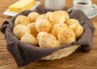 Typical brazilian cheese bun in a basket, coffee and butter