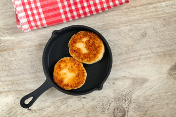 Homemade warm cheesecakes on a black pan, top view, flat lay. Selective focus with copy space