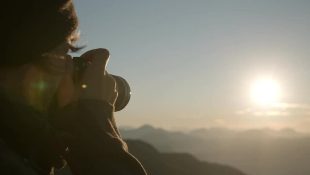 Hiker takes picture of sunset standing on a mountain peak (Austrian Alps)