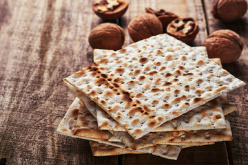 Matzah and walnut. Traditional ritual Jewish bread on old wooden rustic background. Passover food. Pesach Jewish holiday of Passover celebration concept.