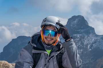 Fototapeta na wymiar portrait of a climber with helmet and goggles in front of mountains