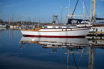Yachts and reflections in the water in Birdham Pool Marina which is situated in Chichester Harbour.