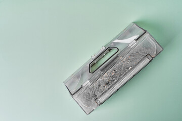 Transparent dust container of the robot vacuum cleaner after cleaning the house, completely clogged...