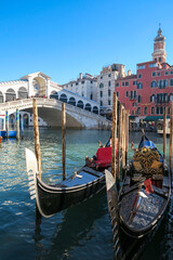 Fototapeta na wymiar Rialto bridge in Venice with gondolas on Grand Canal in vertical shot