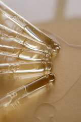 Pipettes with oil or serum on a golden background.