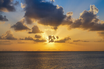 Obraz premium The sun behind clouds on sunset sky at the lake.