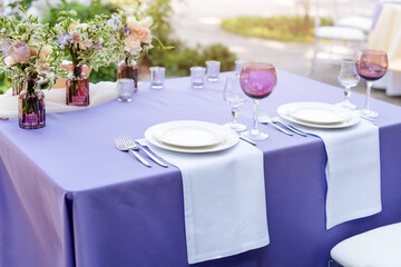 Flower table decorations for holidays and wedding dinner. Table set for holiday, event, party or wedding reception in outdoor restaurant.