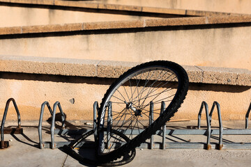 Stolen bicycle wheel. Chained front bicycle wheel locked. Crime and vandalism in the streets.
