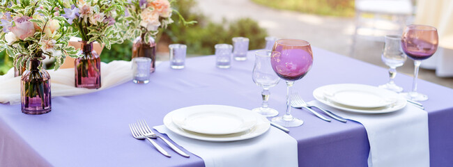 Flower table decorations for holidays and wedding dinner. Table set for holiday, event, party or wedding reception in outdoor restaurant.