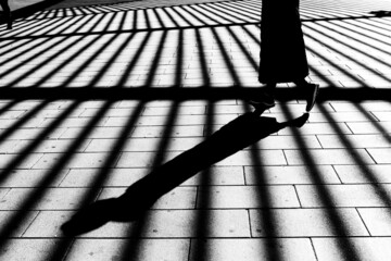 Shadow of a woman walking. Modern concept of sad and monotonous urban life.