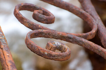 Element of a very rusty wrought iron fence. Abandoned architectural buildings.