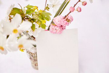 Spring delicate postcard mock up with vase of spring pink, white and yellow flowers. Woman's day, invitation, Mother's day, wedding, birthday card concept. Naturecore concept. Aesthetic cottagecore.