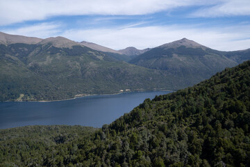 Fototapeta na wymiar View of the forest and hills around the deep blue water lake Gutierrez in Bariloche, Patagonia Argentina. 