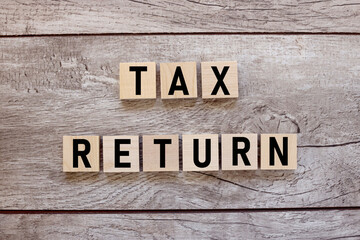 tax return text on wood blocks. on a wooden table