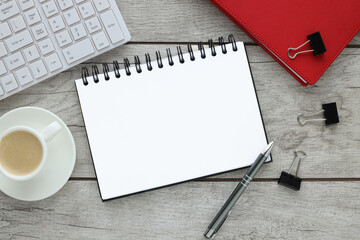 Flat lay accountant or freelancer workplace with keyboard, red notepad. stationery on a light background