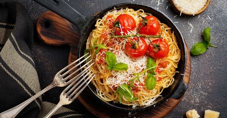 Pasta spaghetti. Traditional Italian dish of spaghetti with tomato sauce and parmesan cheese in ceramic plate on light concrete background. Selective focus. Top view.