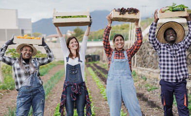 Multi generational gardening people holding wood box with fresh organic fruit and vegetable