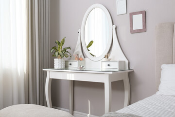 Elegant dressing table with mirror near window in bedroom