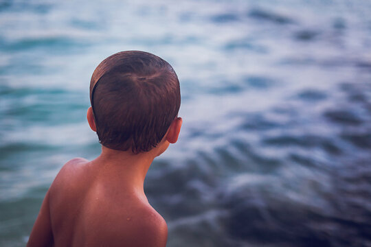 Close up of young boy looking at the ocean