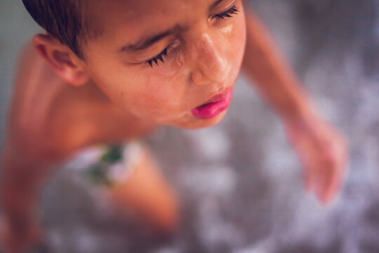 Close up of young boy coming out of the ocean