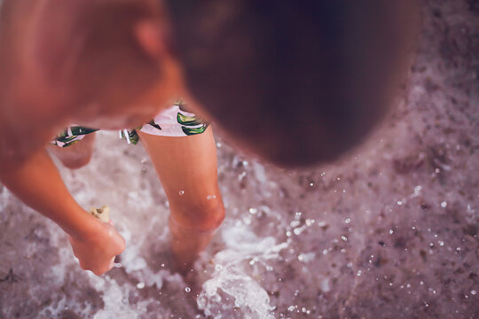 Close up of young boy walking in the water